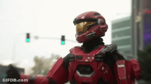 A Man In A Red Helmet Is Standing In Front Of A Traffic Light GIF