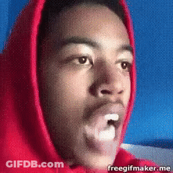 A Man In A Red Hoodie Is Blowing A Bubble In His Mouth GIF