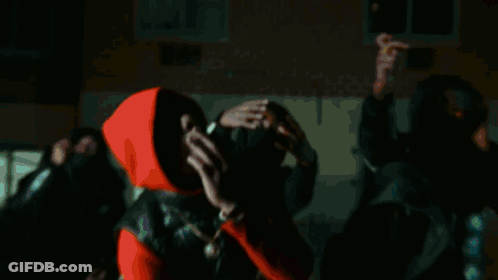 A Man In A Red Hoodie Looks Up At Something GIF
