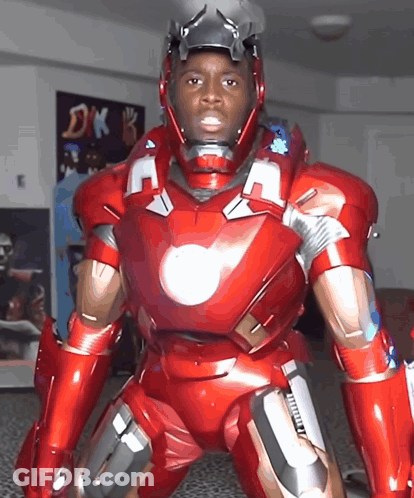 A Man In A Red Iron Man Suit Is Standing In Front Of A Dk Sign GIF
