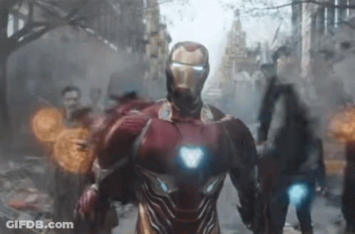 A Man In A Red Iron Man Suit Is Walking Down A City Street GIF