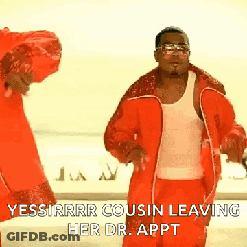 A Man In A Red Jacket And Red Pants Is Dancing With A Woman In A White Tank Top . GIF