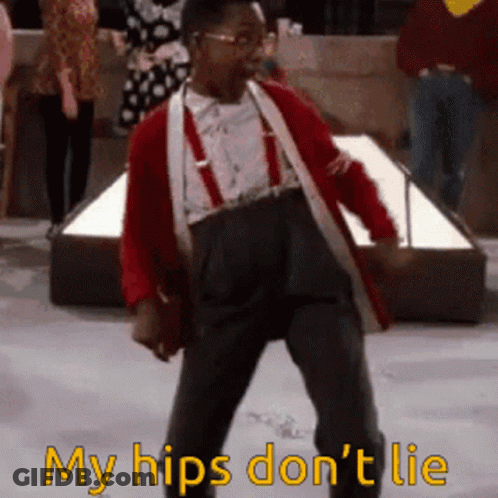 A Man In A Red Jacket And Suspenders Is Dancing With The Words " My Hips Don 'T Lie " Below Him GIF