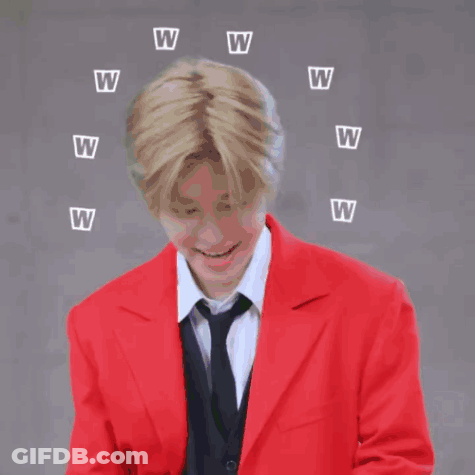 A Man In A Red Jacket And Tie Is Laughing With Letters W Flying Around Him GIF