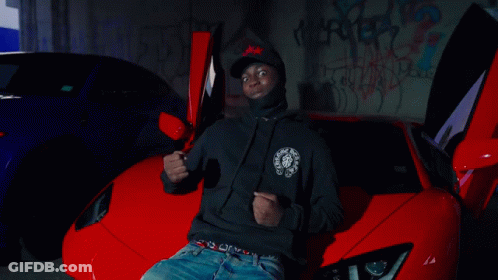 A Man In A Red Jacket Is Dancing In Front Of A Group Of People GIF