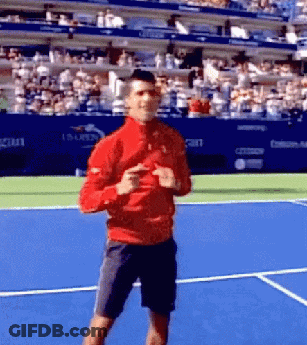A Man In A Red Jacket Is Dancing On A Tennis Court GIF