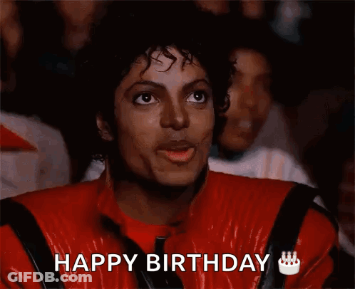 A Man In A Red Jacket Is Eating A Piece Of Food And Says Happy Birthday GIF
