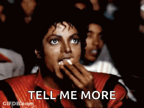 A Man In A Red Jacket Is Eating Popcorn And The Words Tell Me More Are Above Him GIF