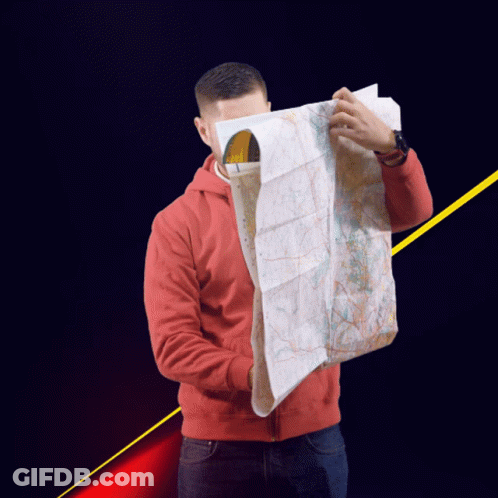A Man In A Red Jacket Is Holding A Map Over His Face GIF
