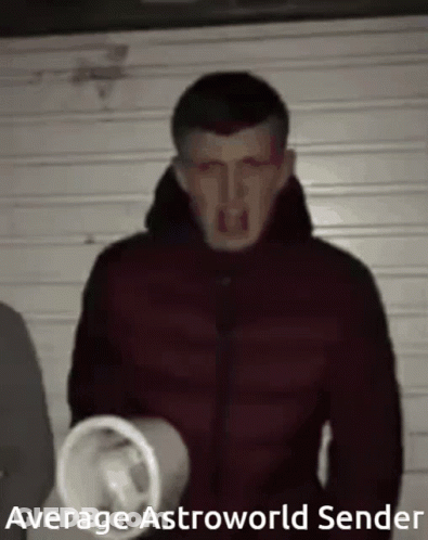 A Man In A Red Jacket Is Holding A Megaphone In His Hand . GIF