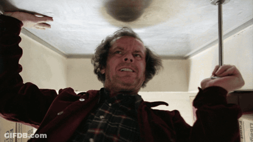 A Man In A Red Jacket Is Holding A Screwdriver In His Hand GIF