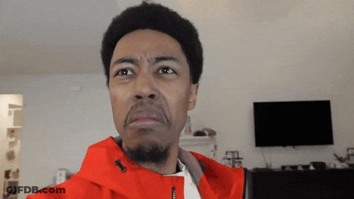 A Man In A Red Jacket Is Making A Face GIF