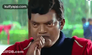A Man In A Red Jacket Is Making A Funny Face With His Hands To His Mouth . GIF