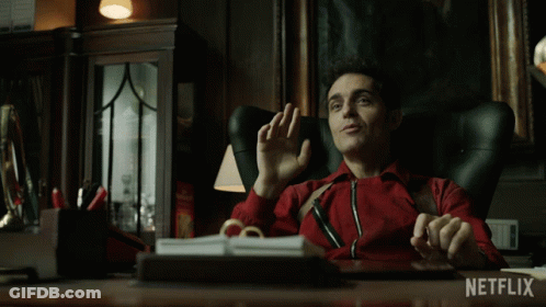 A Man In A Red Jacket Is Sitting At A Desk With Netflix Written On The Bottom GIF