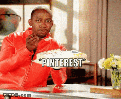 A Man In A Red Jacket Is Sitting At A Table Eating A Cake With The Words Pinterest Above Him GIF