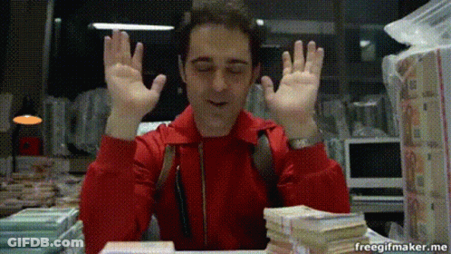 A Man In A Red Jacket Is Sitting At A Table With A Stack Of Money In Front Of Him . GIF