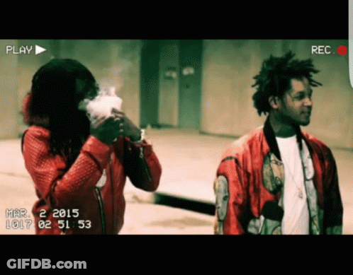 A Man In A Red Jacket Is Smoking A Cigarette While Another Man Looks On GIF