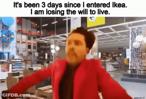 A Man In A Red Jacket Is Standing In A Store . GIF