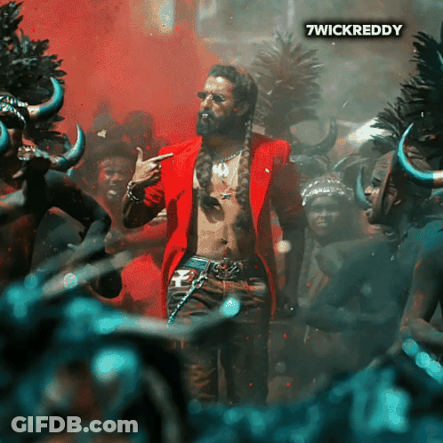 A Man In A Red Jacket Is Standing In Front Of A Crowd And The Words 7Wickreddy Are On The Bottom Right GIF
