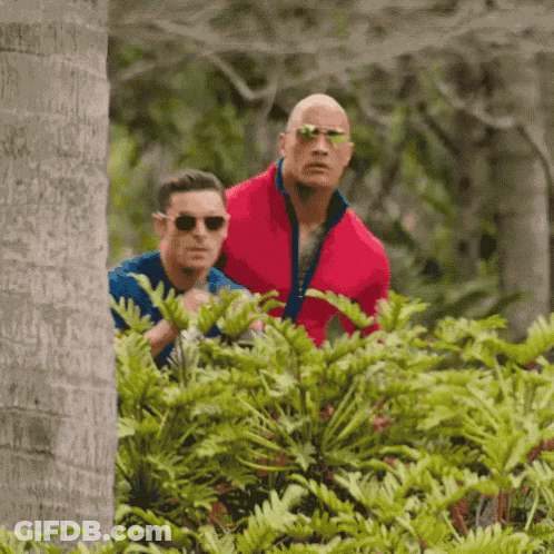 A Man In A Red Jacket Is Standing Next To Another Man In A Blue Shirt . GIF