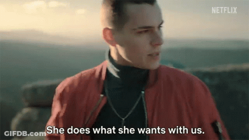 A Man In A Red Jacket Is Talking To A Woman Who Is Standing Next To Him . GIF