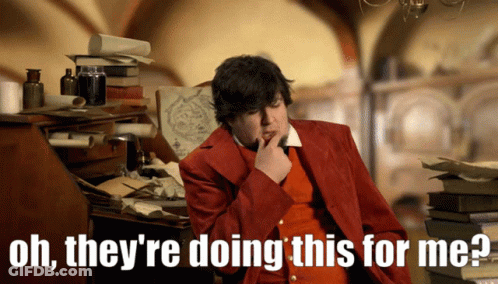 A Man In A Red Jacket Says Oh They 'Re Doing This For Me While Sitting At A Desk GIF