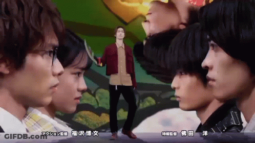 A Man In A Red Jacket Stands In Front Of A Group Of People With Asian Writing On The Bottom GIF