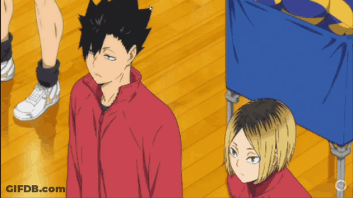 A Man In A Red Jacket Stands Next To Another Man GIF
