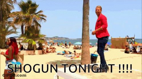 A Man In A Red Jacket Stands On A Beach With The Words Shogun Tonight !!! GIF