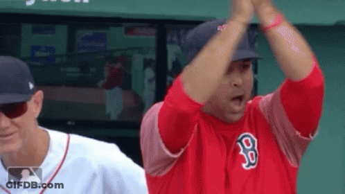 A Man In A Red Jersey With The Letter B On It Is Giving A High Five To Another Man . GIF