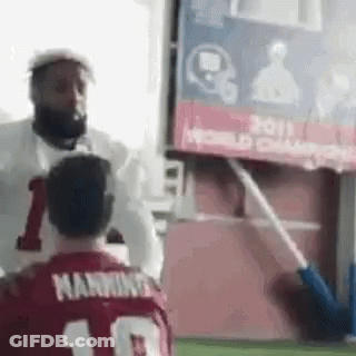 A Man In A Red Jersey With The Number 10 On It Is Standing Next To Another Man In A White Shirt . GIF