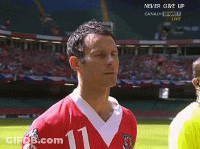 A Man In A Red Jersey With The Number 11 On It Stands On A Soccer Field GIF