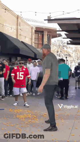 A Man In A Red Jersey With The Number 15 On It Stands In Front Of A Crowd Of People GIF