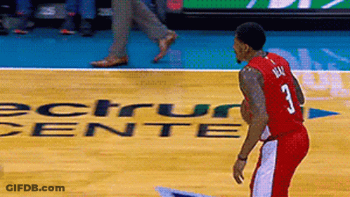 A Man In A Red Jersey With The Number 3 On It Stands On A Basketball Court GIF