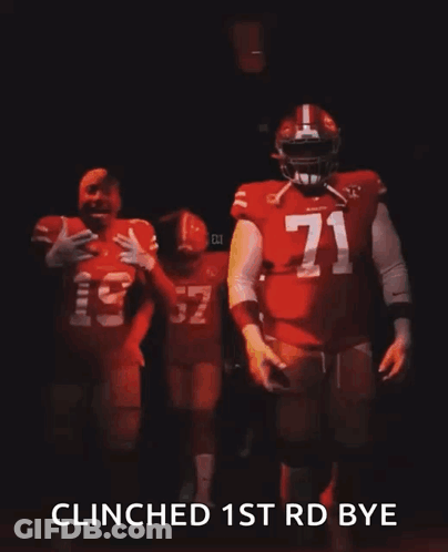A Man In A Red Jersey With The Number 32 On It Is Walking In The Dark . GIF