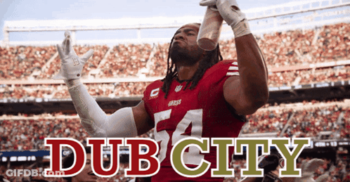 A Man In A Red Jersey With The Number 54 On It Holds Up A Cup GIF