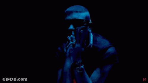A Man In A Red Jumpsuit Is Standing In A Diamond Shaped Room With The Letter H On The Bottom GIF