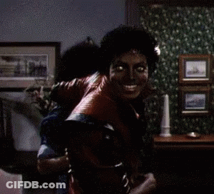 A Man In A Red Leather Jacket Is Holding Another Man On His Back GIF