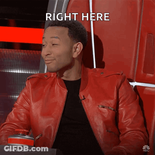 A Man In A Red Leather Jacket Sitting In A Chair With The Words Right Here Above Him GIF