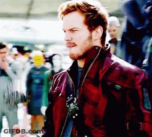 A Man In A Red Leather Jacket Stands In Front Of A Crowd Of People GIF