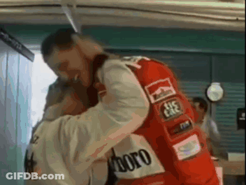 A Man In A Red Marlboro Jacket Is Hugging Another Man In A White Jacket . GIF