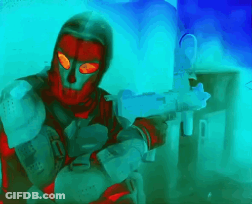 Man In Red Mask Holding Gun In Front Of Blue Wall GIF