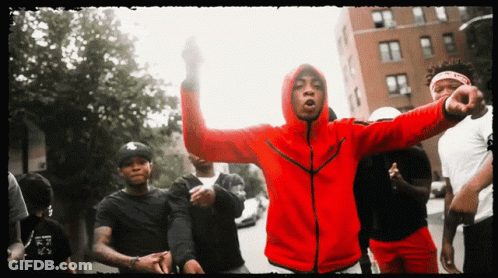 A Man In A Red Nike Jacket Stands In A Crowd GIF