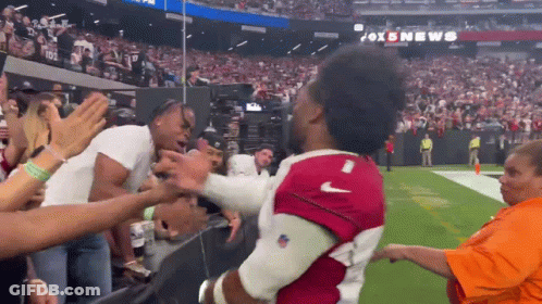 A Man In A Red Nike Jersey Is Being Lifted By A Crowd GIF