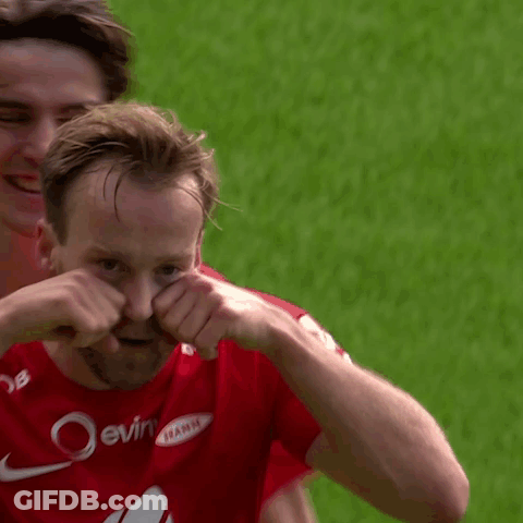A Man In A Red Nike Jersey Is Covering His Face With His Hands While Another Man Looks On . GIF