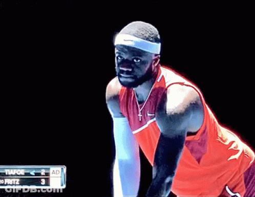 A Man In A Red Nike Shirt Is Standing In Front Of A Scoreboard That Says Fritz GIF
