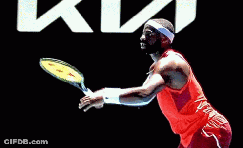 A Man In A Red Nike Tank Top And Headband Is Playing Tennis GIF