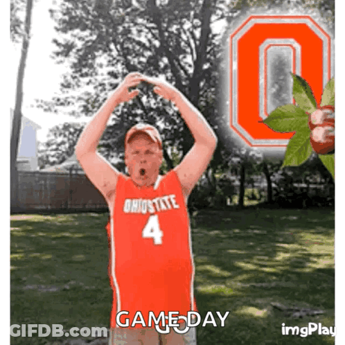 A Man In A Red Ohio State Jersey Stands In Front Of A Large Ohio State Logo GIF