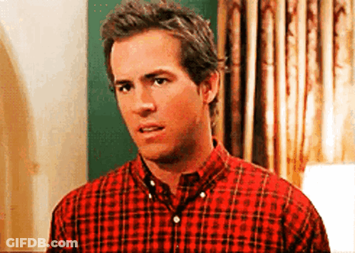 A Man In A Red Plaid Shirt Is Standing In Front Of A Lamp . GIF