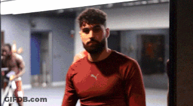 A Man In A Red Puma Shirt Stands In A Gym GIF